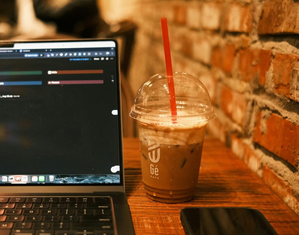 Iced coffee and laptop on a wooden table